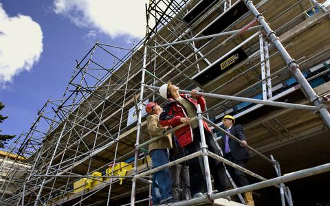 Medewerkers van de Arbeidsinspectie controleren de veiligheid van een bouwsteiger. 