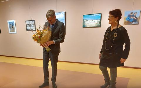 Burgemeester André van de Nadort krijgt bij de opening van de expositie in de Kijkzaal een bloemetje aangereikt door voorzitter Jannie Bouma. 