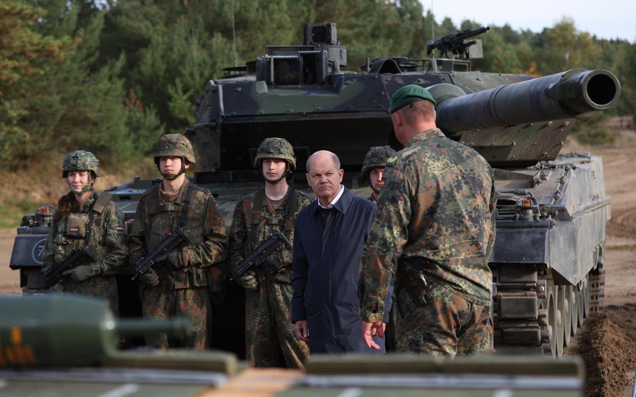 De Duitse bondskanselier Olaf Scholz krijgt uitleg van een militair tijdens een legeroefening.  