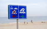 Een bord aan het strand waarschuwt voor de gevaren van zwemmen in zee. 