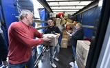 Vrijwilligers laden de vrachtwagen met hulpgoederen in voor Oekraïne.