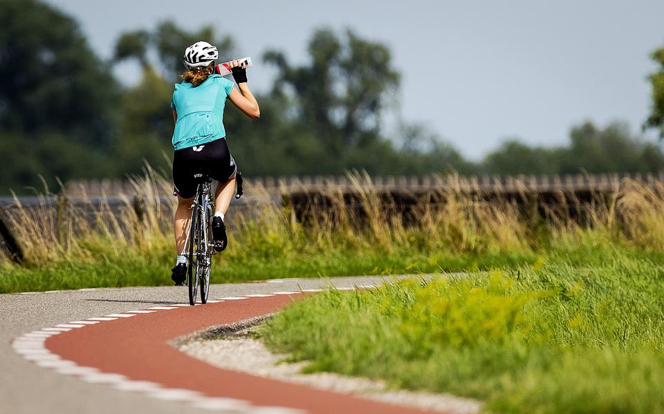 Wielrenner op de dijk in de omgeving van Schalkwijk. 