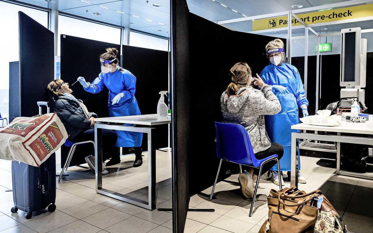 Reizigers uit Zuid-Afrika laten zich bij aankomst op de luchthaven testen op het coronavirus.