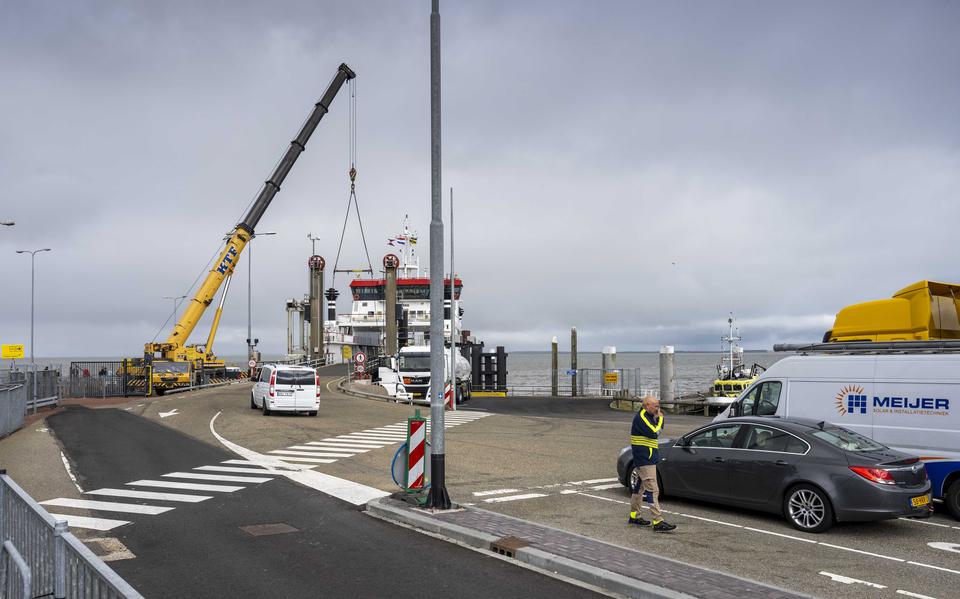 Een kraan bedient de autobrug in Holwert zodat auto's de boot van Wagenborg op en af kunnen rijden. 