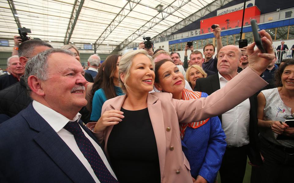 Michelle O'Neil maakt een foto met haar partijgenoten nadat bekend geworden is dat haar partij Sinn Féin de verkiezingen heeft gewonnen.