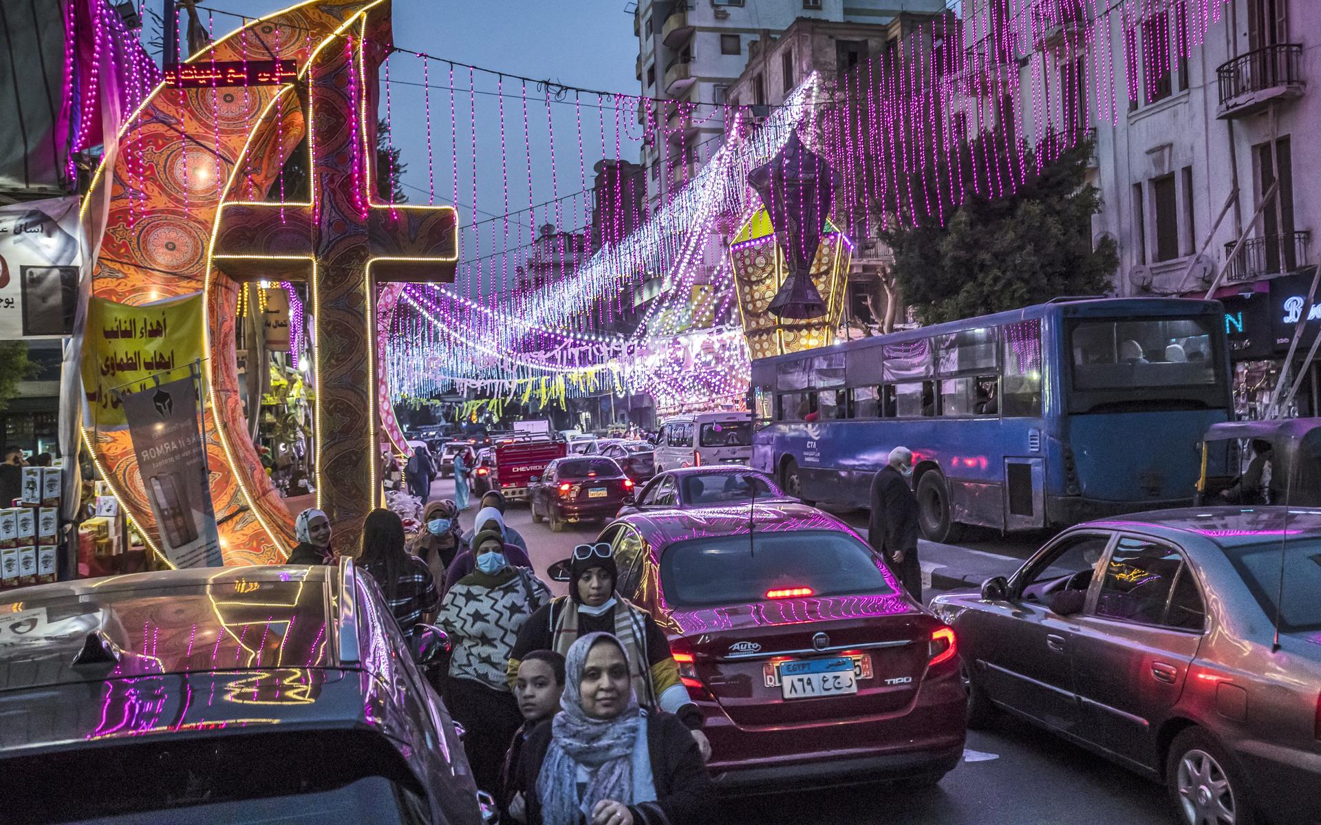 Versiering van een gigantische halve maan en een kruis markeerden in 2021 het begin van de islamitische heilige vastenmaand ramadan in een voornamelijk christelijke wijk van Cairo.