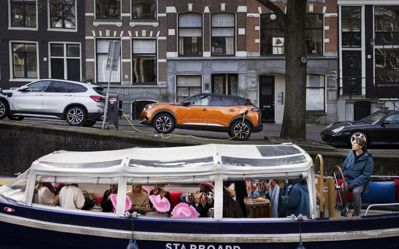 Een elektrische auto staat te laden in het centrum van Amsterdam.