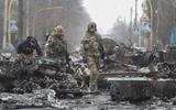 Oekraïense soldaten tussen vernietigd Russisch materieel in de straten van Boetsja.