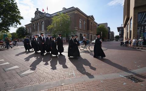 De hoogleraren van Campus Fryslân schrijden van het Beursgebouw naar de Grote Kerk.
