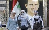 Portret van Assad op een gevel in Damascus. 