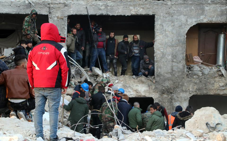 Syriërs kijken bij hulpverlening. 