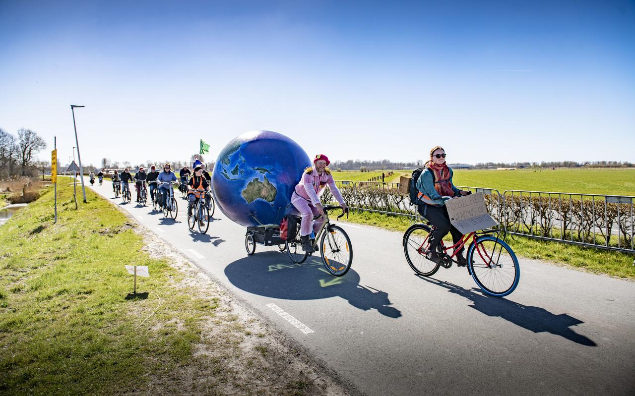 Activist Dirk Kuiken met op een karretje achter zijn fiets de wereldbol. 