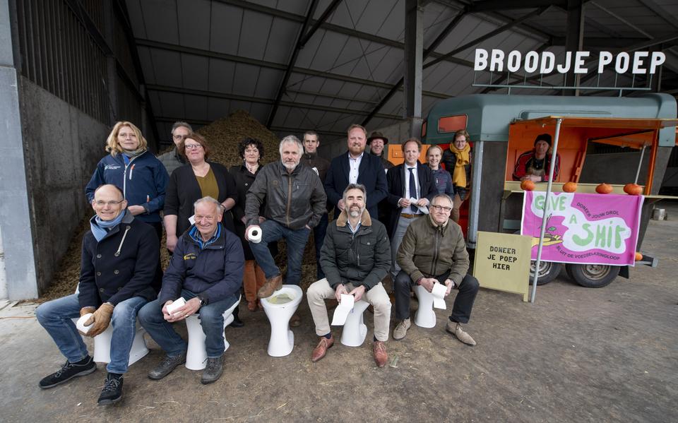 Friese bestuurders op en bij het toilet. Van links naar rechts op de pot:  Wetsus-directeur Cees Buisman, inititiatiefnemer Theo Mulder, Sjoerd de Hoop, van Fryske Biologische Boeren, Evert Jan van Nijen van Circulair Friesland en GrienLinks statenlid Jochum Knol. Midden: dijkgraaf Luzette Kroon, Monique Plantinga van de Friese Milieufederatie, wethouders Bauke Dam van Súdwest-Fryslân en Abel Reitsma van Leeuwarden, . Achterste rij: Pieter de Jong van de Nederlandse Melkveehouders Vakbond, Sieta van Keimpema van Farmer Defense Force,  Arjan de With van de Vereniging tot Behoud van Boer & Milieu, Albert van der Ploeg, Nienke Bakker van Agrarische Jongeren Friesland en CDA-statenlid Maaike Prins. Boer Albrecht Finnema staat onder de luifel. 
