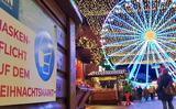 De kerstmarkt in het Duitse Meppen woensdag, borden wijzen de bezoekers erop dat een mondkapje verplicht is.