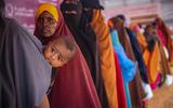 Somalische vrouwen met kinderen staan in de rij voor voedselhulp. Mede door de slechte voedselvoorziening sterven er in Somalië relatief veel jonge kinderen. 