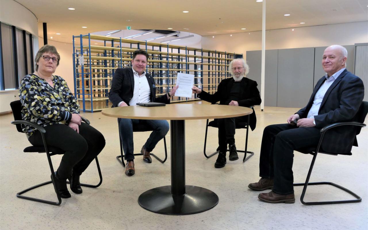 Wethouder Rommy Kempenaar en Alle Flootman, voorzitter van de Voedselbank, tekenen de huurovereenkomst. Links zit bestuurslid Metsje de Vries en rechts Herman de Hoop.