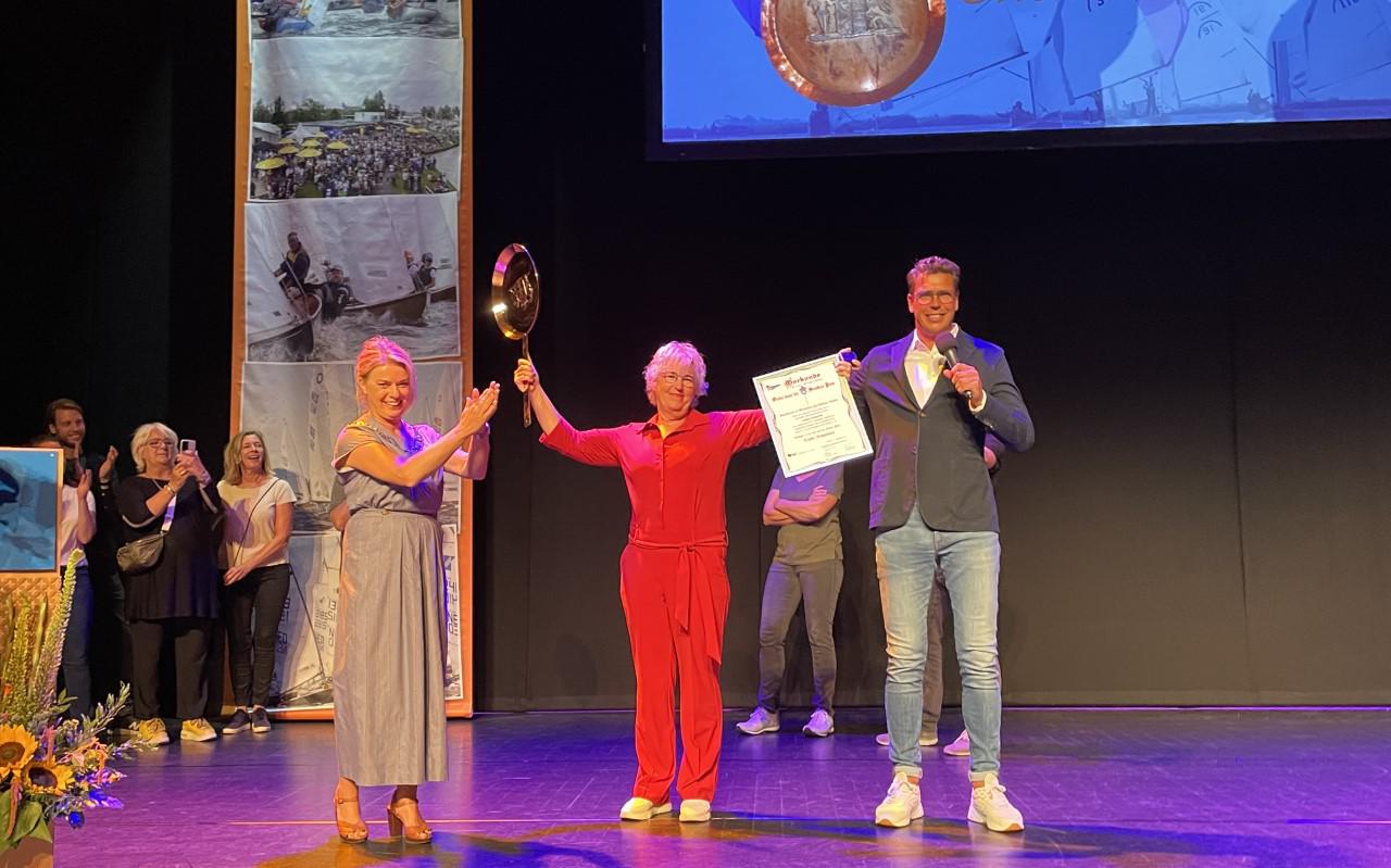 Tineke Schuurmans met haar onderscheiding. Burgemeester Jannewietske de Vries klapt voor haar