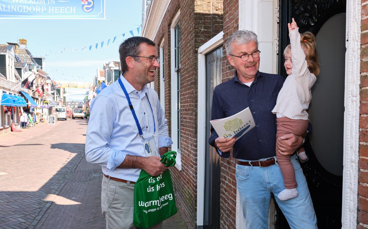 Hegemer Kees van Eck en kleindochter Lieke krijgen uit handen van wethouder Henk de Boer de brochure Warm Heeg. Maandag ging de campagne van start voor het aquathermieproject Warm Heeg.