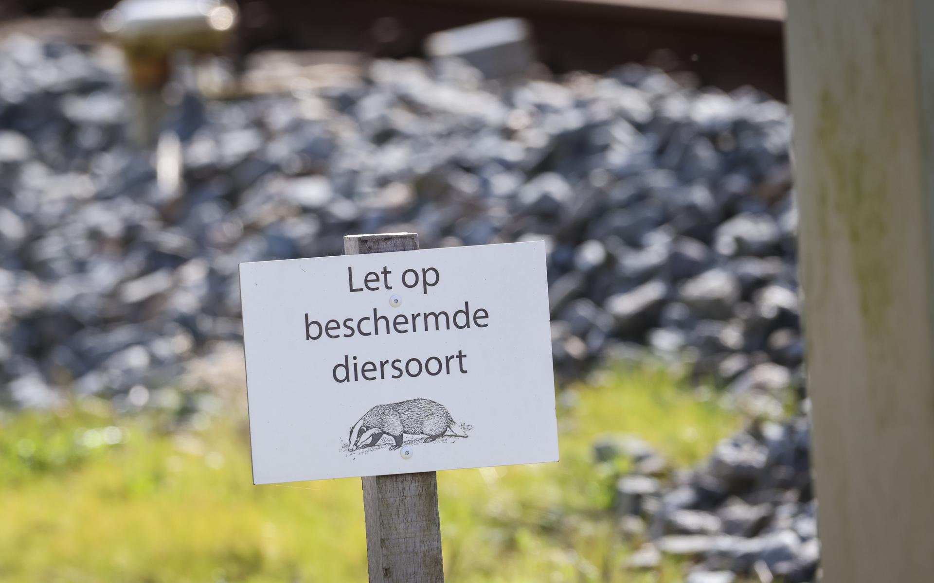 Een bordje met een waarschuwing langs het spoor bij Molkwerum waar spoorbeheerder ProRail de dassen mocht laten verhuizen. 