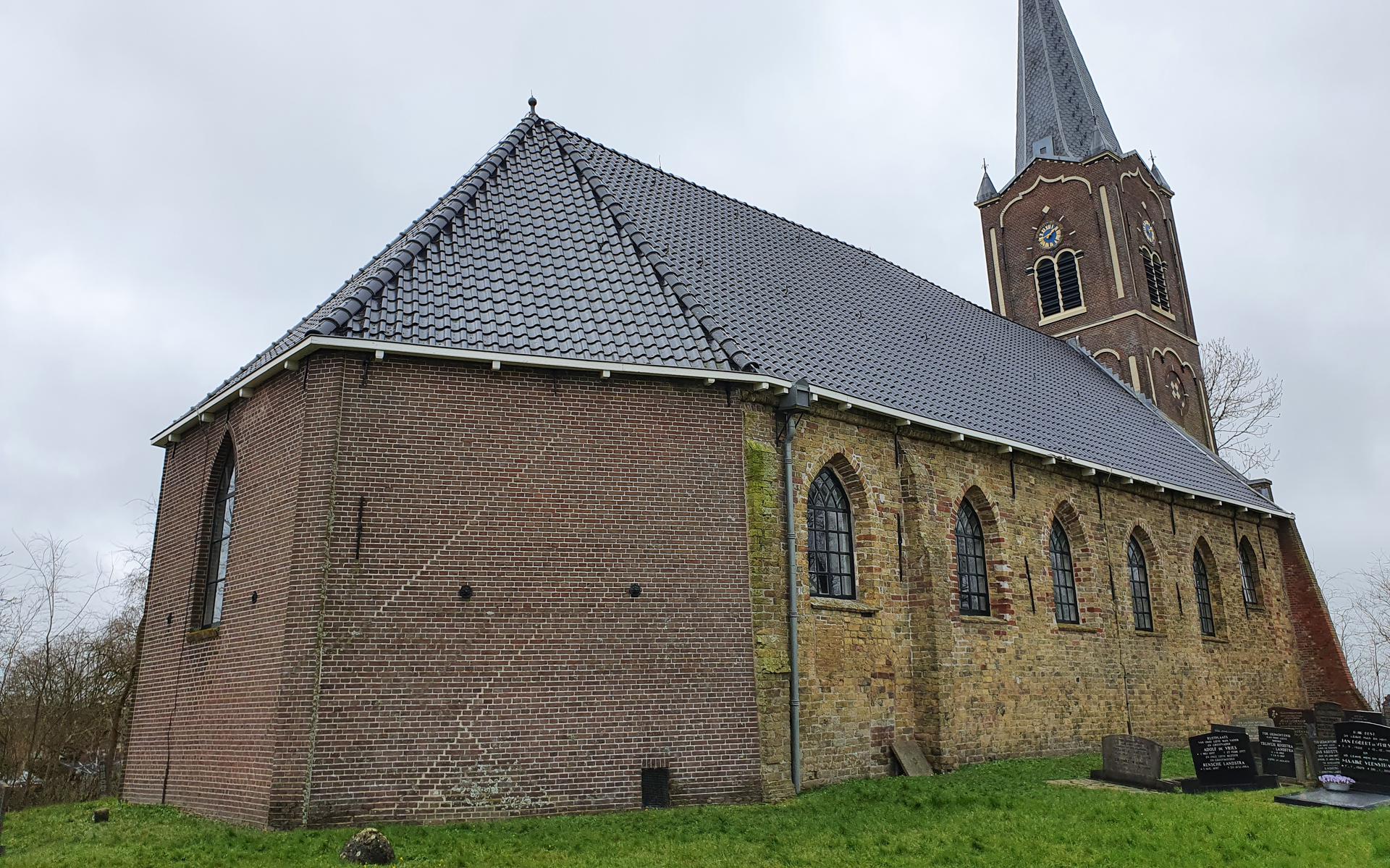 De kerk in Wiuwert van buiten bekeken, met rechts de middeleeuwse muur. 