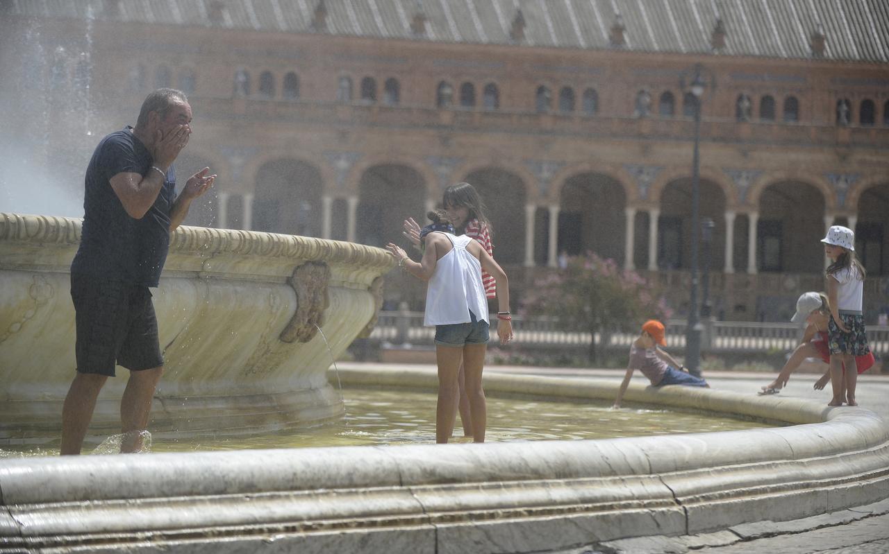 Inwoners van het Spaanse Sevilla zoeken verkoeling in een fontein. Inwoners van het Spaanse Sevilla zoeken verkoeling in een fontein.
