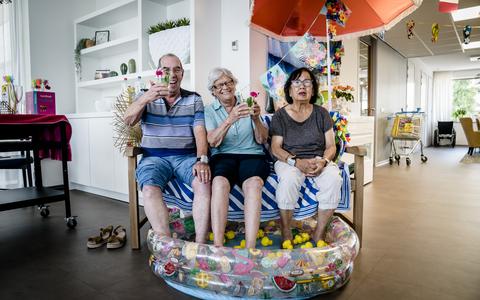 Bewoners van een verzorgingshuis in Zoetermeer zitten ter verkoeling met hun voeten in een zwembadje. 
