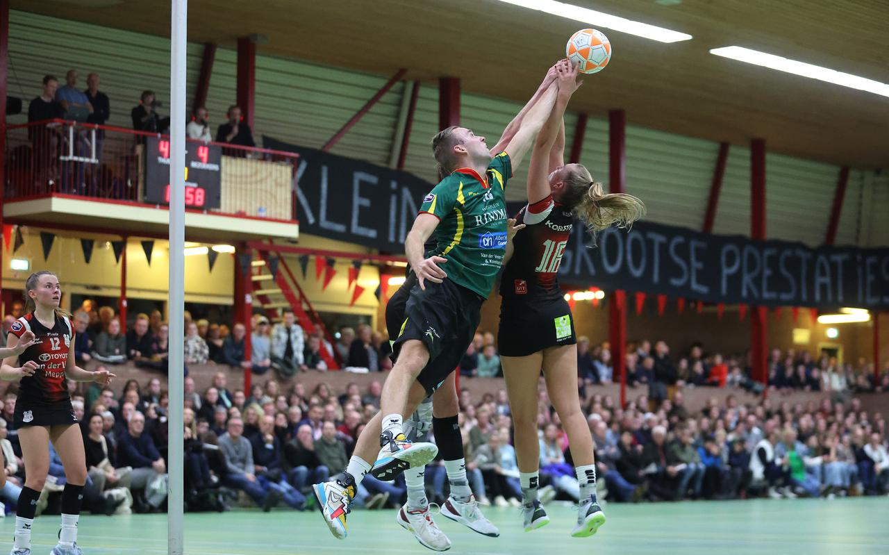 Voor volle tribunes in sporthal De Eendracht 'vliegt' LDODK-speler Julian Frieswijk (in het groen) naar de bal. Rechts Tessa Lap. 