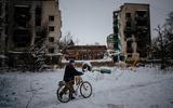 Een loopt met zijn fiets voorbij een verwoest flatgebouw in Borodyanka, nabij de hoofdstad Kiev.