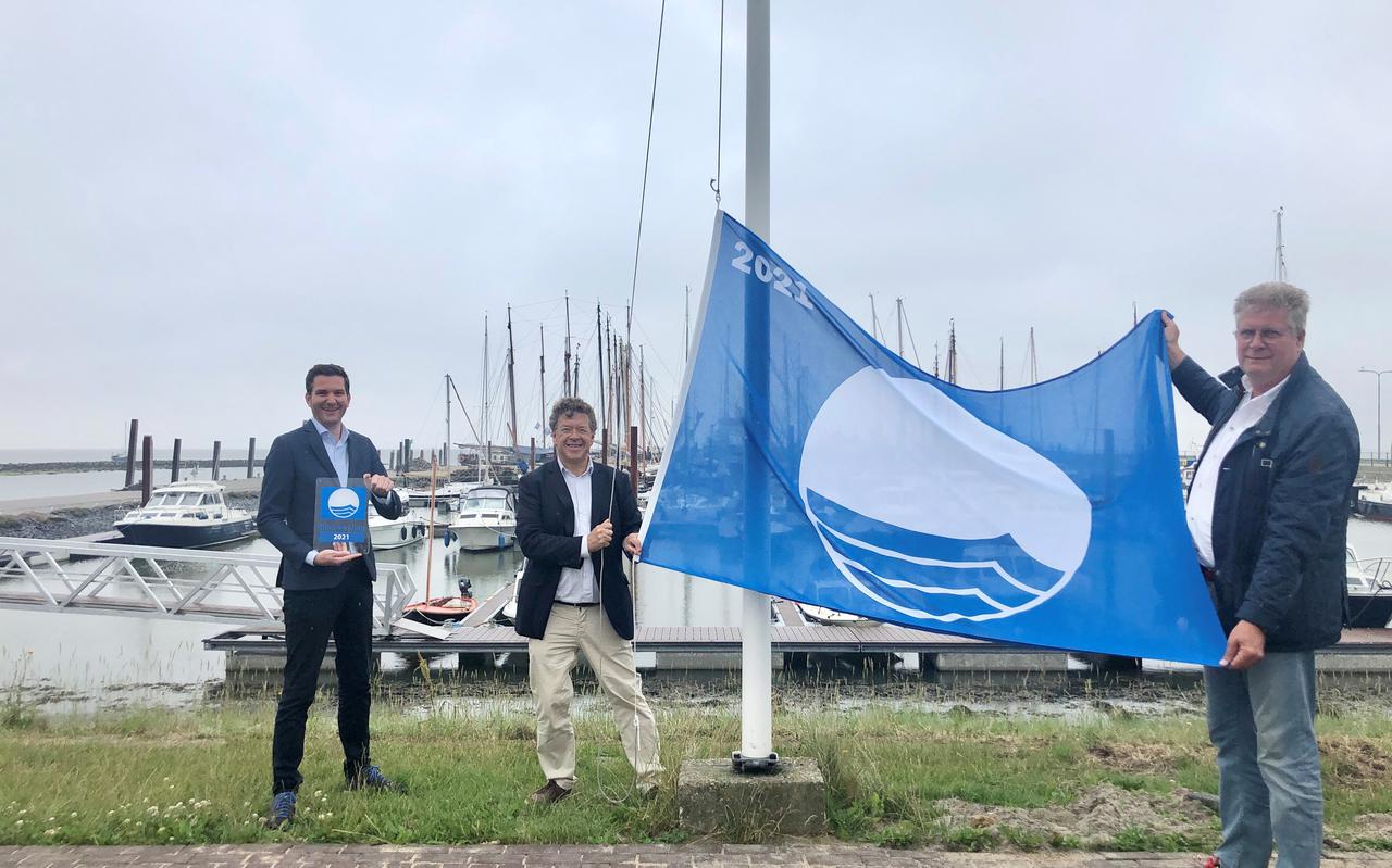 Directeur van de organisatie Erik van Dijk overhandigt de Blauwe Vlag aan de voorzitter van het bestuur van
de jachthaven Upt Hidema, in aanwezigheid van wethouder Theo Faber. 