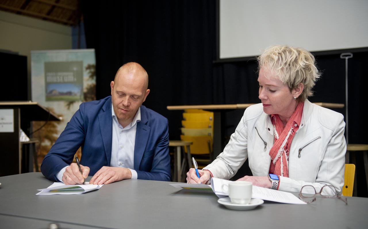 Wethouder Hein de Haan en Siegrid Hoekstra, directeur-bestuurder WoonFriesland tekenen de overeenkomst. 