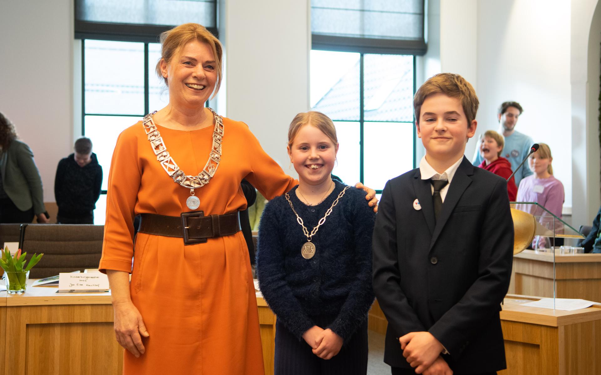 Burgemeester Jannewietske de Vries samen met de nieuwe kinderburgemeester Noor Bosman (midden) en Jan Eise Kruithof (rechts) die afzwaaide als kinderburgemeester. 