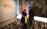 Kerkgangers steken kaarsen aan in de Domkerk, voorafgaand aan een gebedsmoment. 