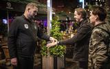Beveiligers van Café Het Plein in Rotterdam checken de bezoekers of ze een coronapolsbandje of de CoronaCheck-app hebben.