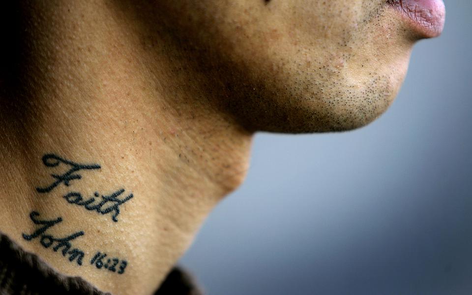AMSTERDAM - In het Olympisch stadion in Amsterdam viert de Nederlandse Pinkstergemeente haar 100 jarig bestaan "In Vuur en Vlam voor God en Mensen". Een bezoeker heeft een tattoo van het woord "Faith" (Geloof) in zijn nek. 