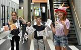 Amber, Ingmar en Marije met een vlaggenlijn vol doelen van Vakantieschoolleerlingen. 