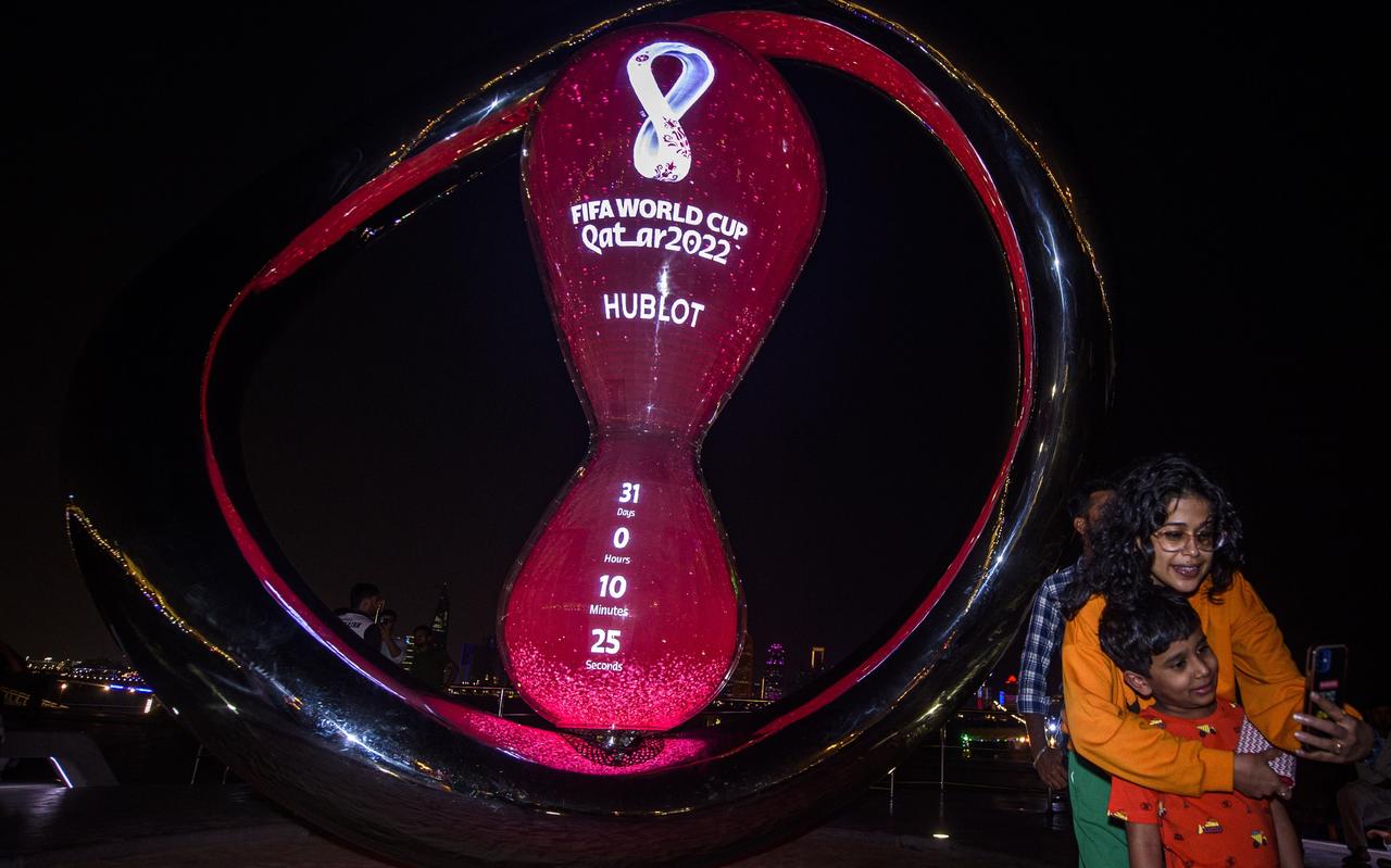 Mensen nemen selfies voor de klok in Doha die aftelt naar het wereldkampioenschap voetbal. Mensen nemen selfies voor de klok in Doha die aftelt naar het wereldkampioenschap voetbal.