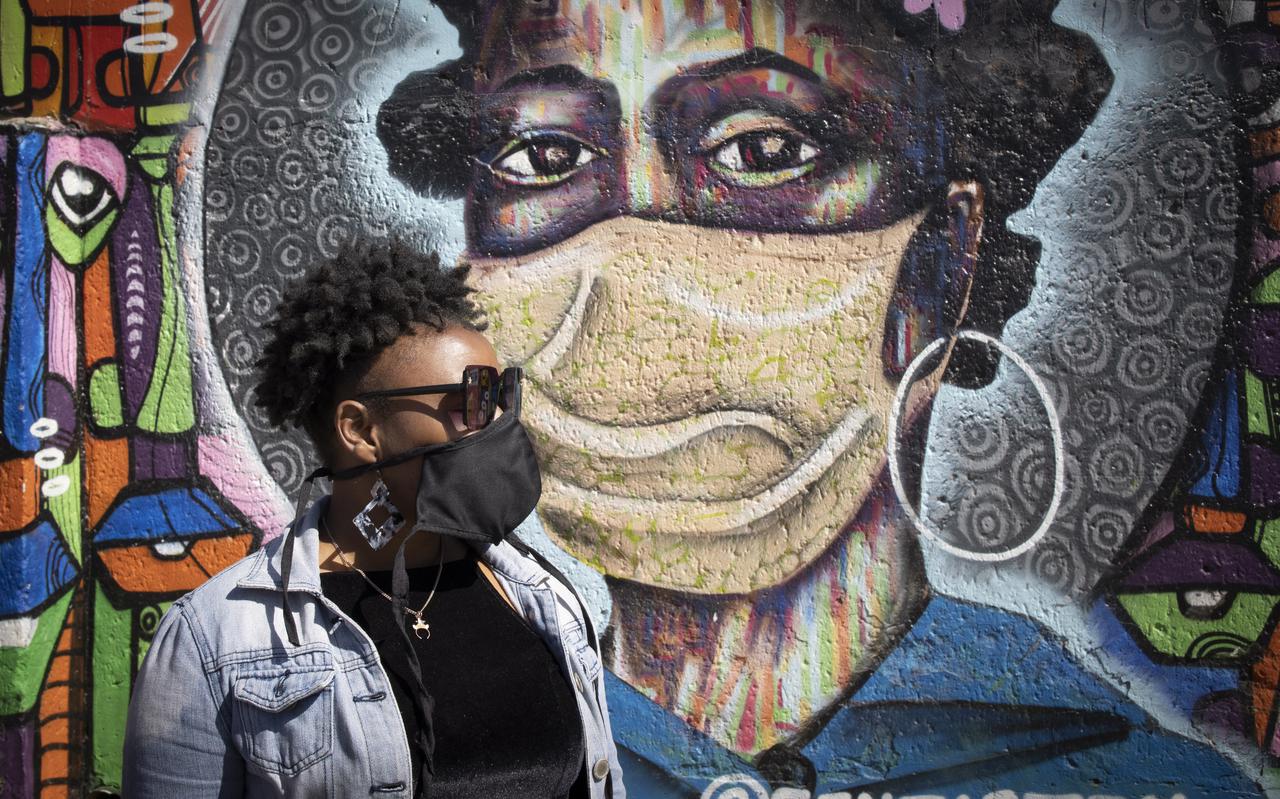 Graffiti op een muur in de wijk Sohoto in Johannesburg wijst Zuid-Afrikanen op het belang van het dragen van een mondkapje in de strijd tegen corona. 