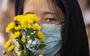 Een jonge Chinese vrouw rouwt om slachtoffers van een brand in een flatgebouw in Urumqi. De brand met tien doden leidde dtot demonstraties. De strenge lockdown zou de reddingsoperatie voor de flatbewoners hebben bemoeilijkt.