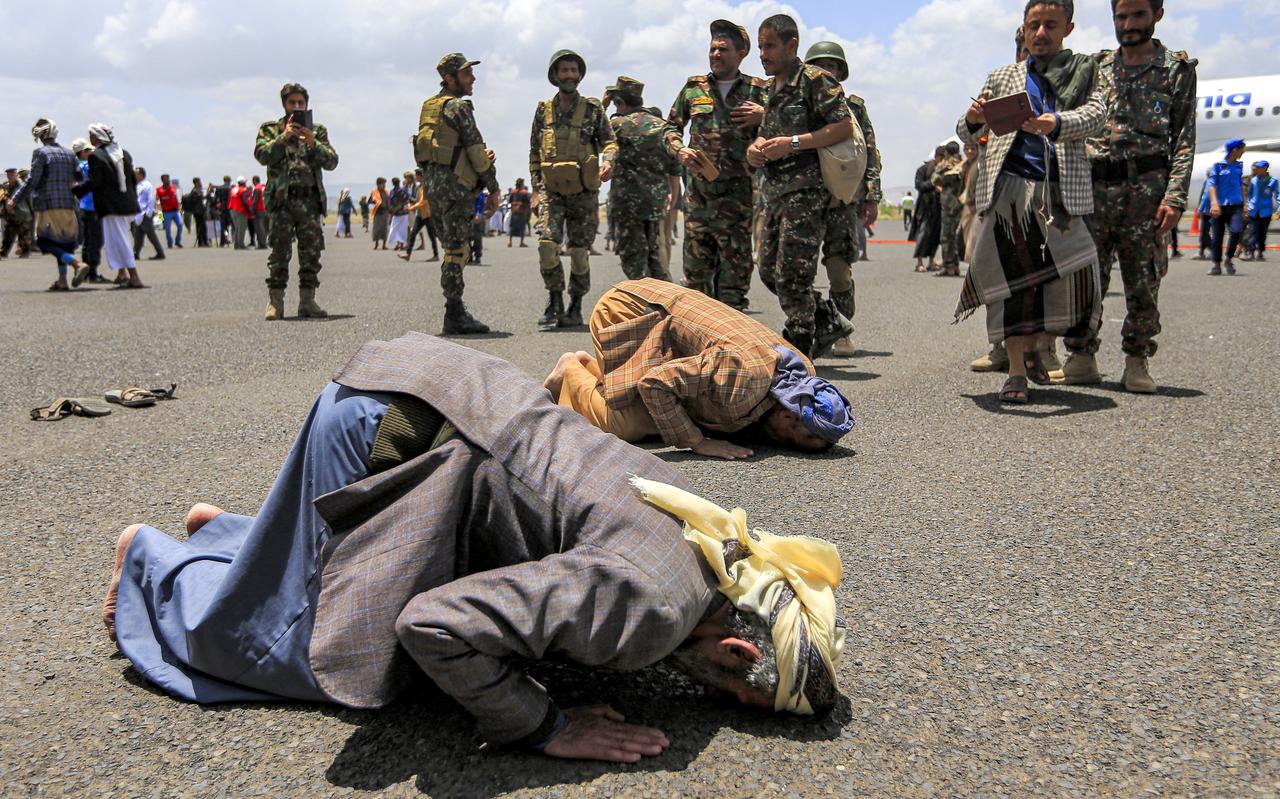 Bij een gevangenruil vrijgekomen Houthi-rebellen kussen bij aankomst in Sanaa de grond van de luchthaven, april 2023.