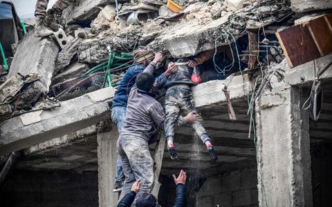 Reddingswerkers halen een meisje levend vanonder het puin in Jindires, Syrië.