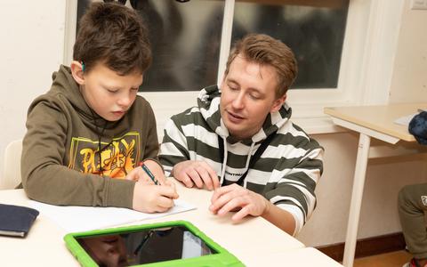 Een leerling van de Plataanschool in Leeuwarden (Proloog) krijgt uitleg van leerkracht Maarten.