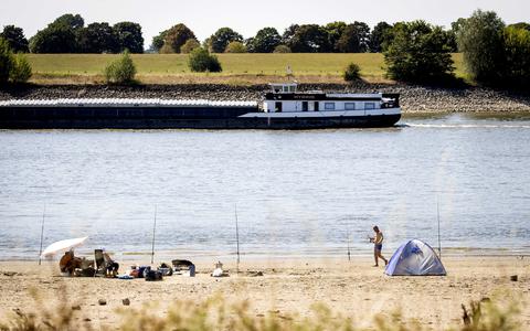 Strandgangers langs de Rijn. De binnenvaart ondervindt flinke hinder door de lage waterstanden. 