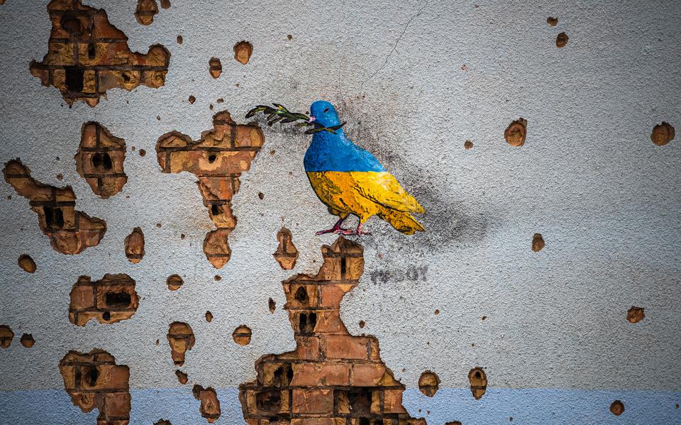 Sporen van Russische beschietingen omringen een kunstwerk van de straatartiest TvBoy op een muur van het Huis van Cultuur in Irpin dat zwaar werd beschadigd tijdens een Russische aanval op de stad. 