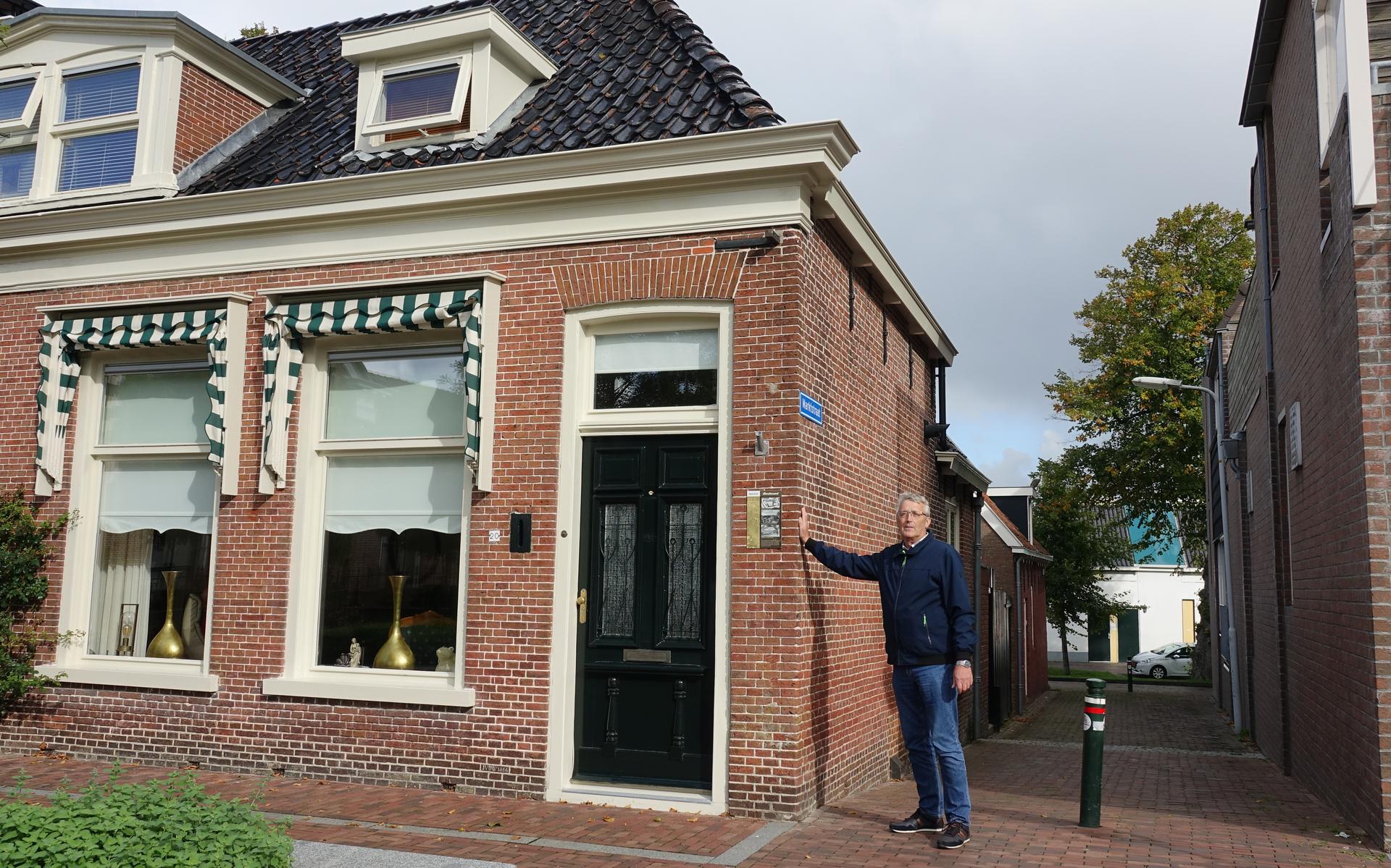 Piet de Haan op het midden van baan bij een hoekhuis op De Markt in Dokkum. 