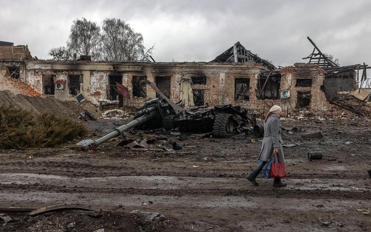 Een inwoner loopt langs een vernietigde Russische tank en stukgeschoten gebouwen in het centrum van Trostianets. Een inwoner loopt langs een vernietigde Russische tank en stukgeschoten gebouwen in het centrum van Trostianets.