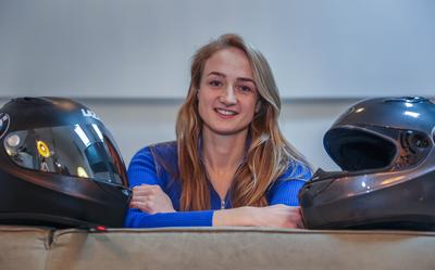 Moniek Klijnstra tussen twee gebruikte en afgeschreven helmen van Dennis Veenker. 