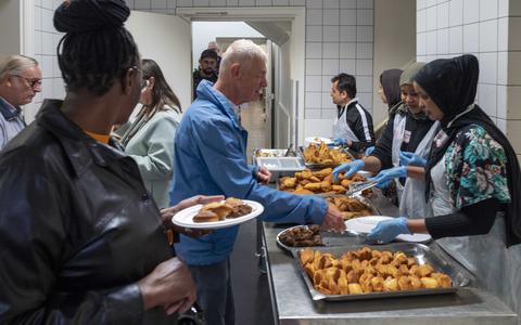 Bezoekers bekijken en proeven lokale gerechten gemaakt door bewoners in het azc te Gilze, zaterdag tijdens de landelijke Open dag.