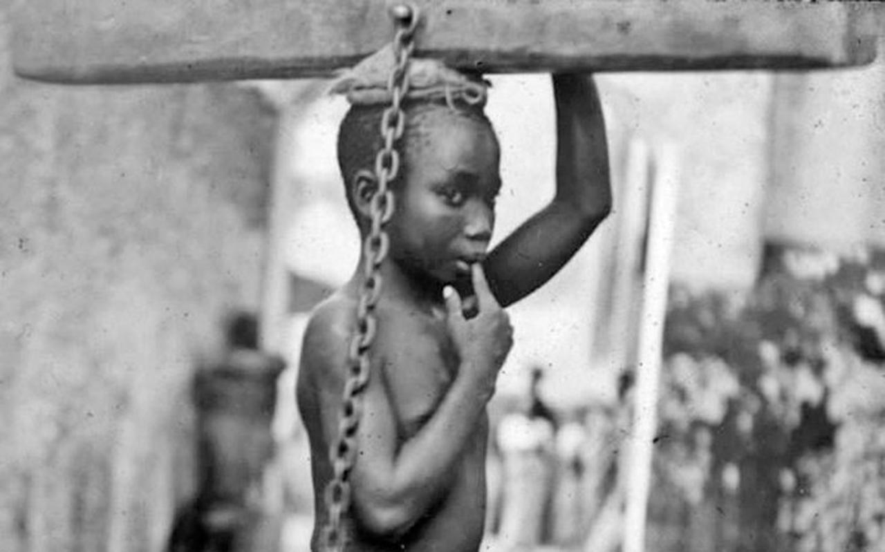 Cypriani Asmani, een jonge slaafgemaakte Afrikaan in Zanzibar-stad die voor straf een jaar lang was vastgemaakt aan een houtblok van vijftien kilo; in juni 1895 werd hij bevrijd door een missionaris. Cypriani Asmani, een jonge slaafgemaakte Afrikaan in Zanzibar-stad die voor straf een jaar lang was vastgemaakt aan een houtblok van vijftien kilo; in juni 1895 werd hij bevrijd door een missionaris.