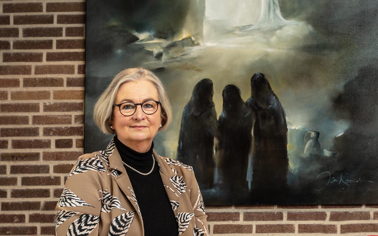 Dominee Ellen Peersmann, met op de achtergrond het schilderij Opstanding van Jan Kooistra.