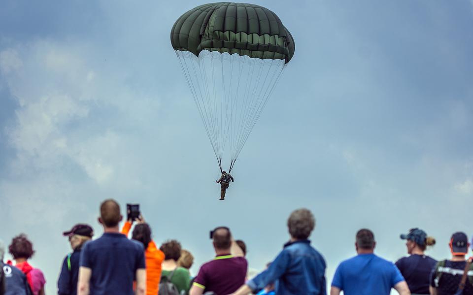 Parachutisten worden gedropt met hun oude bolle parachutes bij de Wapendropping wandel-beleeftocht.